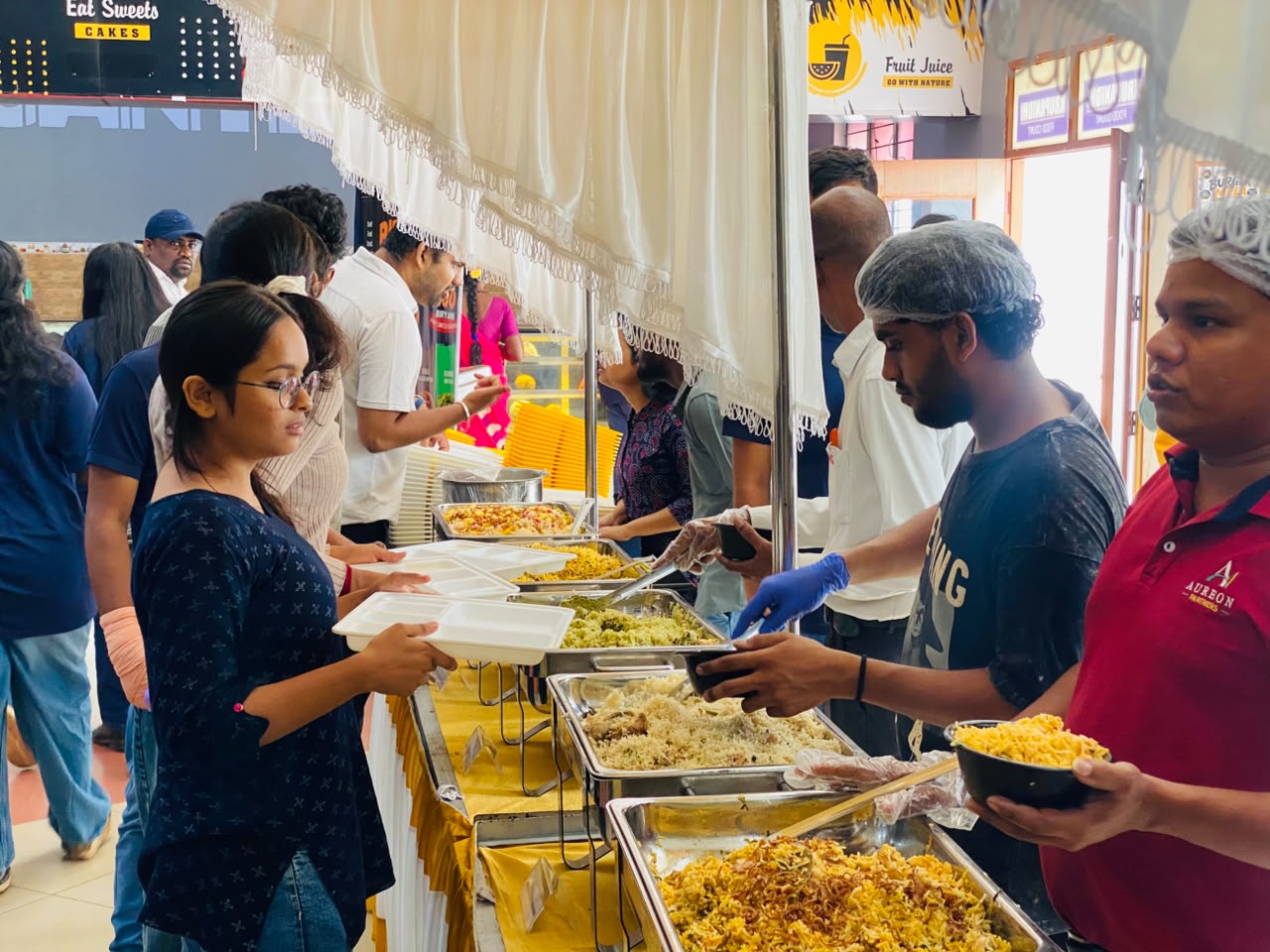 Serving fresh biryani to students at the Grand Biryani Mela, Krupanidhi College Canteen